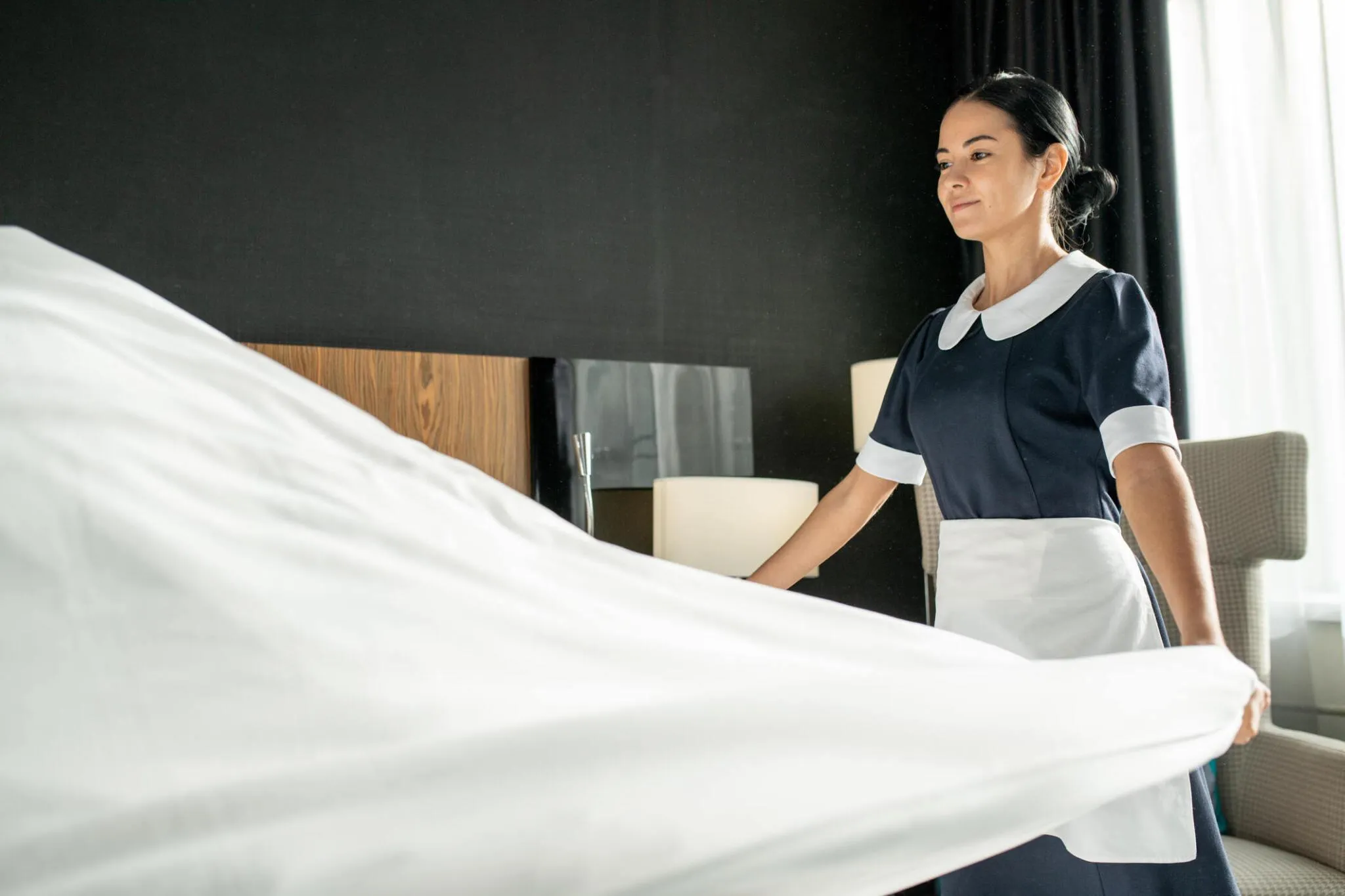 Housekeeper making up a room during Hendersonville hospitality cleaning