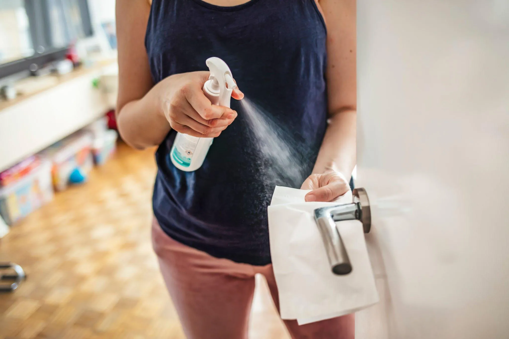 Spraying and sanitizing door handle during deep clean