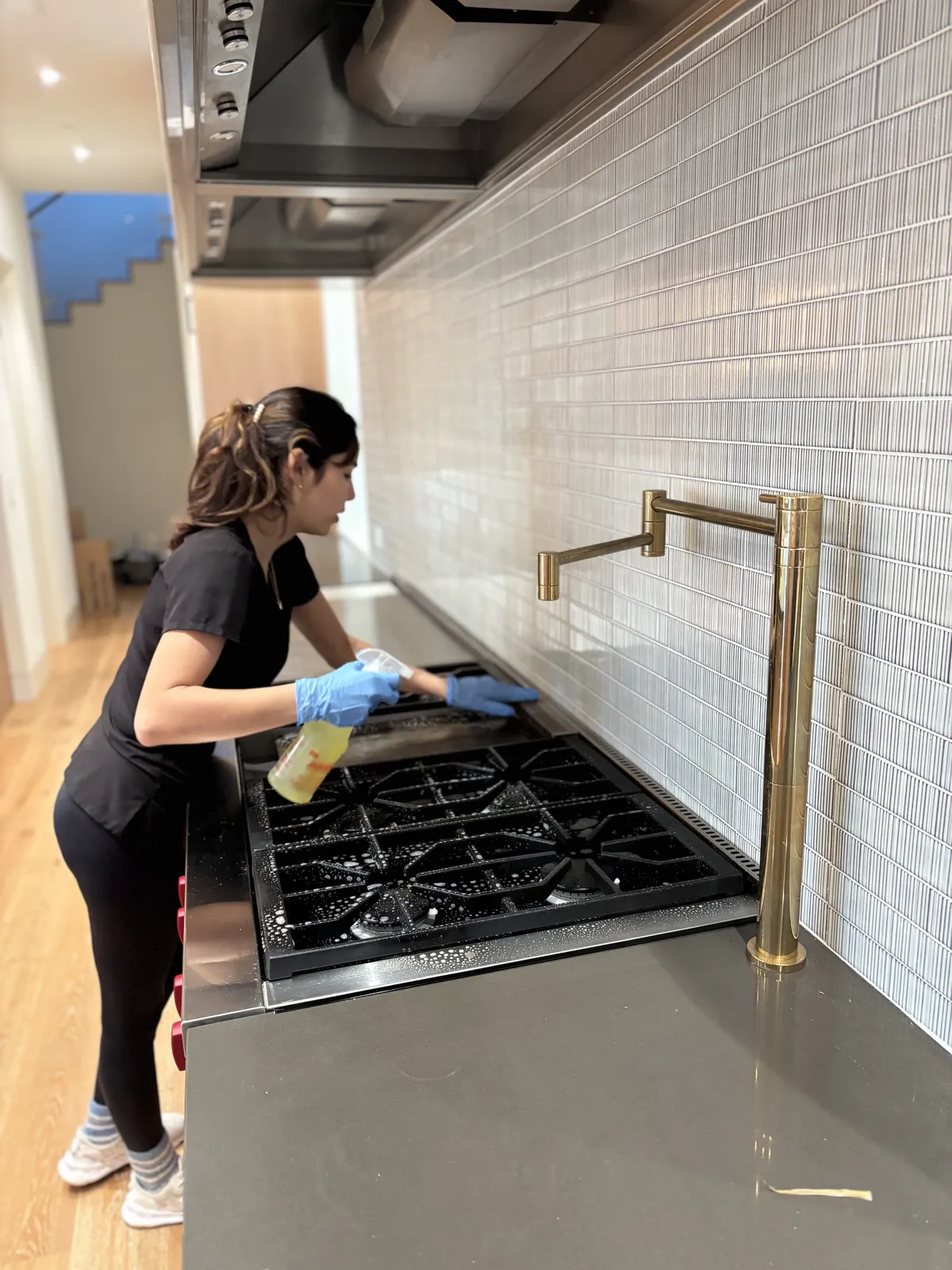 Fresh Start crew member scrubbing a soapy gas cooktop during a Nashville kitchen deep clean
