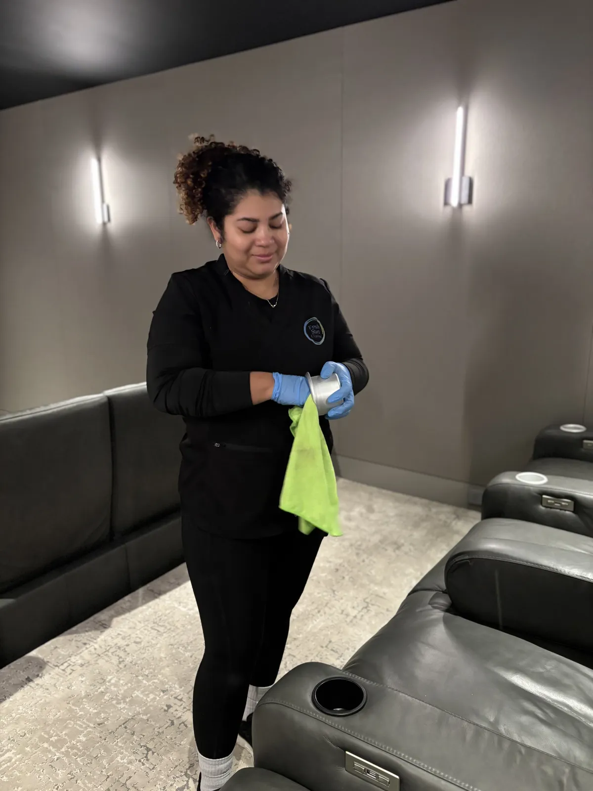 Fresh Start crew member wiping down media room seating in a Nashville home before guests arrive