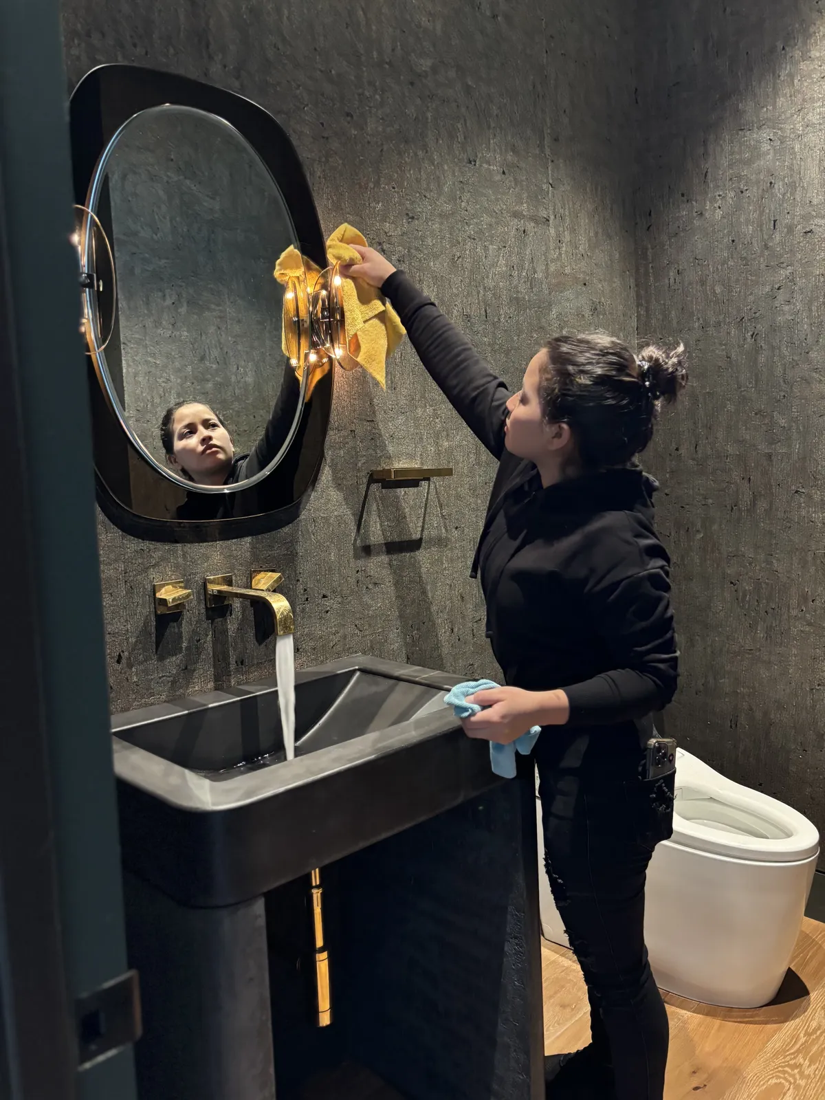 Fresh Start crew member polishing a vanity mirror during a deep clean in a Nashville home