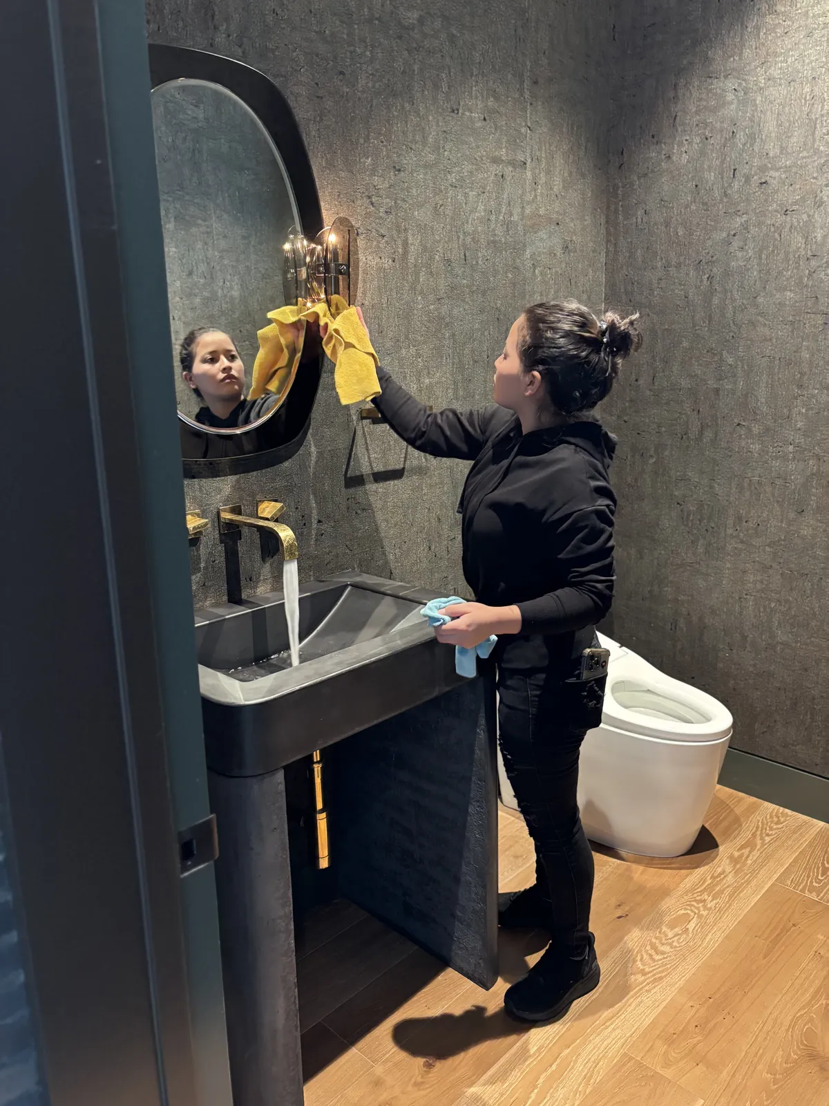 Fresh Start crew member polishing a guest bathroom mirror during a Nashville holiday clean