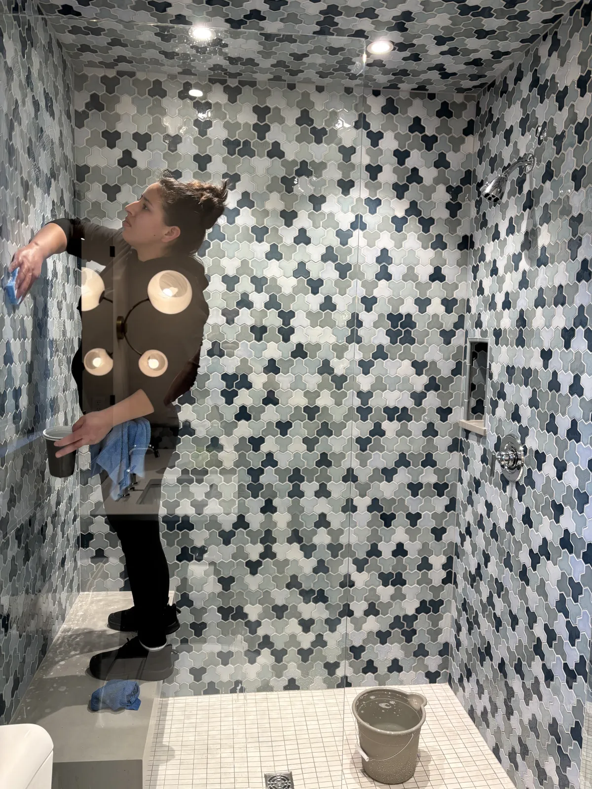 Fresh Start crew member scrubbing mosaic shower tile during a deep clean in Nashville