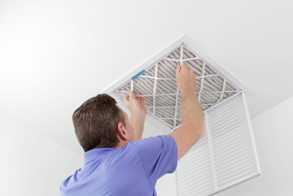 Man replacing air filter during move-in cleaning checklist