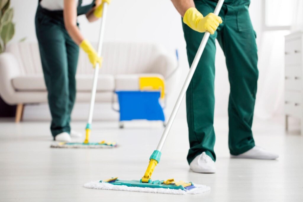 Cleaning crew mopping kitchen floor with professional equipment