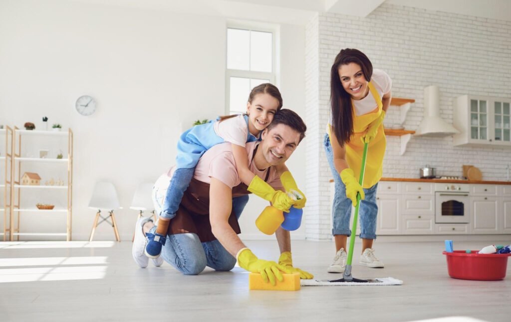 Family scrubbing kitchen floor together during deep clean