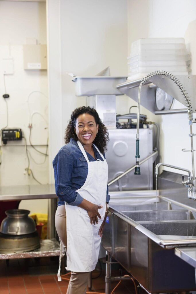 Smiling kitchen worker in commercial kitchen after construction cleaning