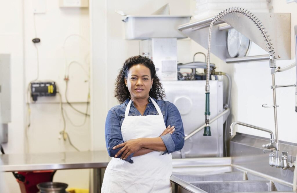 Kitchen worker with arms crossed in clean commercial kitchen