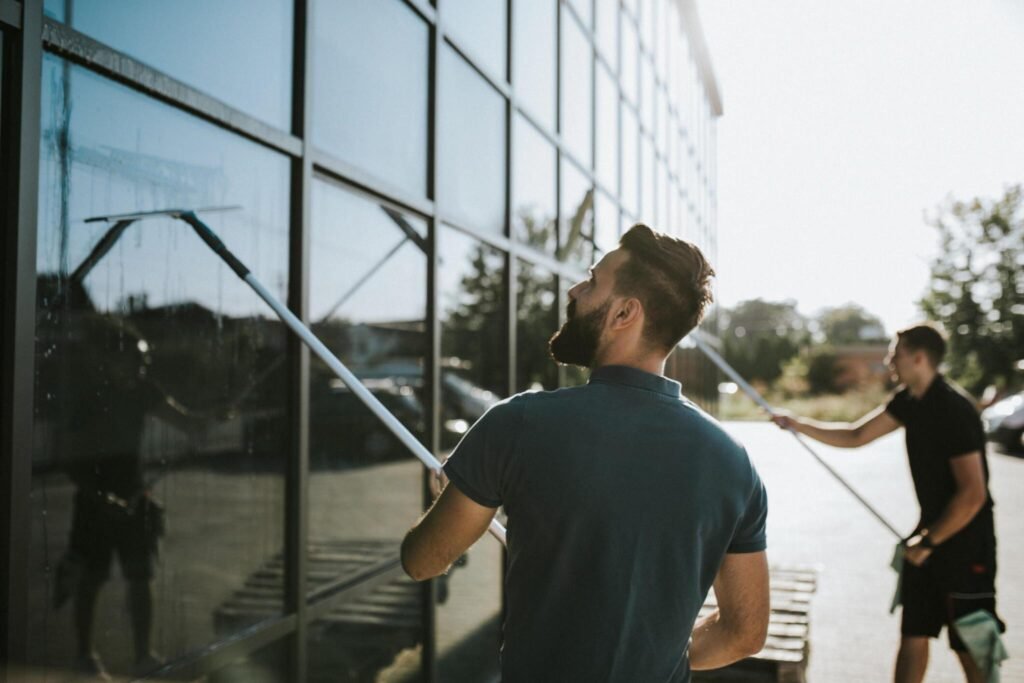 Professional window cleaner using squeegee on exterior glass