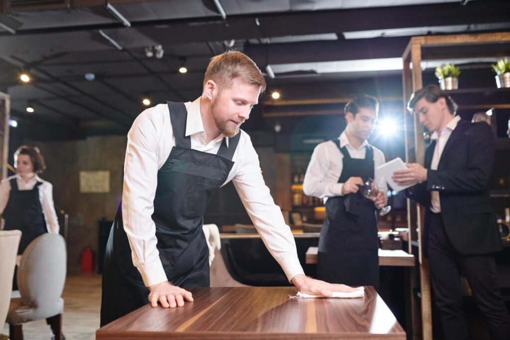 Staff wiping down restaurant table during renovation cleanup