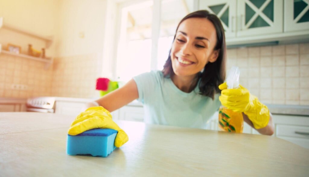 Woman scrubbing kitchen countertop after construction work