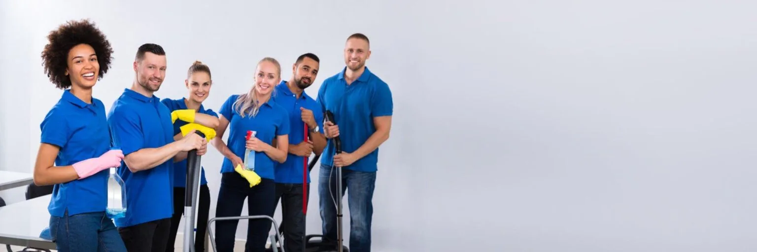 Professional cleaning team in blue shirts with spray bottles and mops